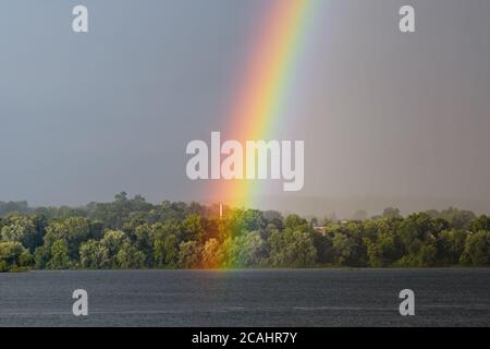 La fine di un arcobaleno durante una tempesta sul fiume Susquehanna nel nord-est degli Stati Uniti. Foto Stock