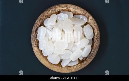 Frutta di palma di zucchero su piastra di legno su sfondo nero. Foto Stock