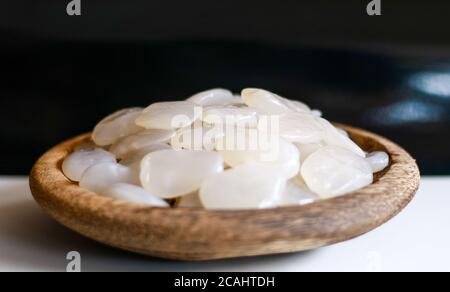 Frutta di palma di zucchero su piastra di legno su sfondo nero. Foto Stock