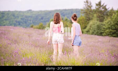 Magog, Canada - Luglio 26 2020: Ragazze giovani in piedi nel campo della lavanda Foto Stock