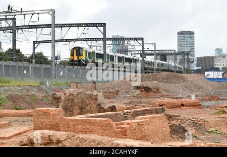 Un treno passa su un argine sopra il cantiere per la stazione HS2 Rail link a Curzon Street a Birmingham, Inghilterra, Regno Unito Foto Stock