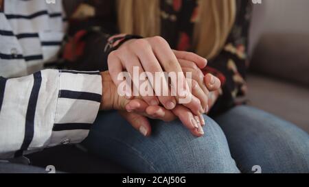 Una figlia che tiene le mani della madre anziana. Concetto di cura e supporto. Filmati 4k di alta qualità Foto Stock