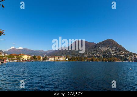Splendida vista panoramica sul lago di Lugano, sulla città di Lugano, sul Monte Bre e sulle Alpi svizzere in una giornata di sole in autunno con nuvola blu, nave da crociera, Foto Stock