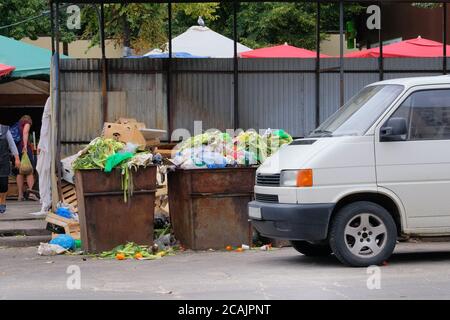 I bidoni della polvere sono pieni di vari rifiuti. La spazzatura è il cumulo lotti dump. Bidoni spazzatura in città. Il cartone viene impacchettato in balle. Foto Stock