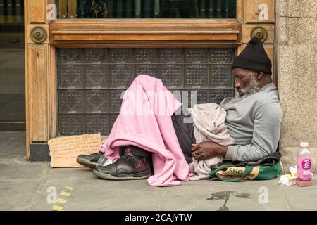 Londra - Agosto 2020: L'uomo senza casa si siede schiaffo nella porta di Londra Street Foto Stock