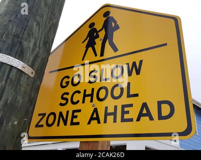 Vai lento, zona scuola davanti al cartello stradale. Foto Stock