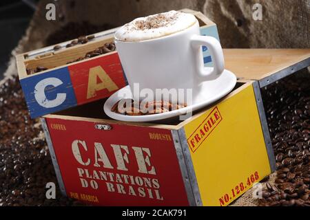 Primo piano di delizioso caffè caldo e cremoso greco mandorle in cima a una colorata scatola di legno Foto Stock