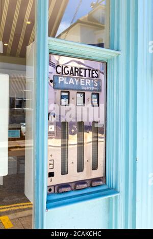 Distributore automatico di sigarette d'epoca su High Street, Whitstable, Kent, Regno Unito Foto Stock