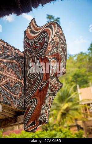 Una scultura in legno stile Bataknese di una testa alla fine di una casa, Indonesia Foto Stock