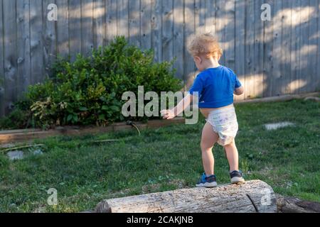 Denver, Colorado - Hendrix Hjermstad, due anni, cerca di equilibrarsi su un log. Foto Stock