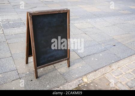 Lavagna vuota sul marciapiede della strada. Mockup per aggiungere il tuo testo. Foto Stock