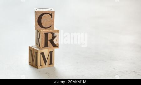 Pila con tre cubetti di legno - lettere CRM significa Customer Relationship Management su di loro, spazio per più testo / immagini sul lato destro. Foto Stock