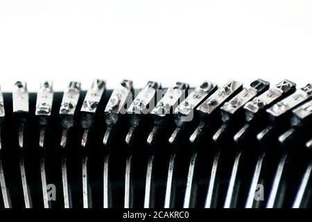 il ferro martella con le lettere impressi all'interno di una vecchia macchina da scrivere. Attrezzi meccanici per la scrittura. Giornalismo vecchio tempo Foto Stock