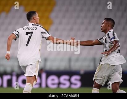 Torino. 7 agosto 2020. Cristiano Ronaldo (L) del FC Juventus celebra il suo secondo gol con il compagno di squadra Alex Sandro durante il round della UEFA Champions League di sedici 2° tappa tra il FC Juventus e l'Olympique Lyonnais a Torino, Italia, 7 agosto 2020. Credit: Federico Tardito/Xinhua/Alamy Live News Foto Stock