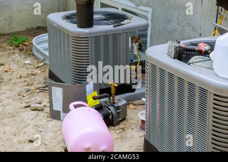 Impianto di climatizzazione assemblato durante la manutenzione preventiva su a. condensatore dell'aria condizionata che rifornisce l'aria condizionata con freon Foto Stock
