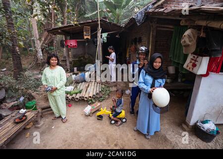 Karangrejo / Indonesia - 1 agosto 2018: Casa locale di famiglia musulmana in zona rurale con la ragazza in uniforme di scuola preparandosi ad andare a scuola con il padre in scooter Foto Stock