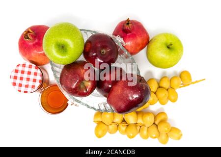 Rosh Hashanah, Capodanno ebraico, simboli tradizionali, Miele in un vaso di vetro, melograni, datteri, mele rosse e verdi. Isolato su sfondo bianco Foto Stock