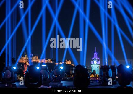 Il cielo sopra la città di Edimburgo è illuminato da My Light Shines on, un'installazione di luci all'aperto per l'Edinburgh International Festival 2020. In tutta la città, tra cui il Castello di Edimburgo, il Festival Theatre e la Usher Hall, partecipano all'evento che segna quello che sarebbe stato il fine settimana di apertura della stagione del festival 2020. Foto Stock