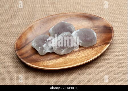 Dolce tradizionale giapponese chiamato Daifuku Mochi su un piatto di legno isolato su sfondo di iuta. Primo piano. Vista dall'alto. Foto Stock