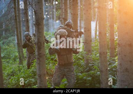 Modern Warfare Soldiers Squad in esecuzione come squadra nella formazione della battaglia Foto Stock