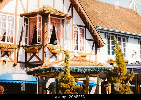 Vista frontale di una splendida casa coloniale tedesca e delle sue finestre decorate con fiori a Vila Germânica, Blumenau - Brasile nel pomeriggio. Foto Stock