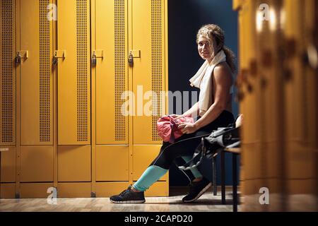 Giovane ragazza di fitness che posa in un armadietto Foto Stock