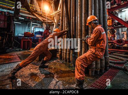 (200808) -- HAIKOU, 8 agosto 2020 (Xinhua) -- i lavoratori svolgono un'attività di perforazione sulla piattaforma petrolifera offshore Kantan No.3 nelle acque settentrionali del Mar Cinese Meridionale, 26 luglio 2020. Il Kantan No.3 è una piattaforma petrolifera semi-sommergibile sviluppata a livello nazionale dalla Cina nel 1983. I suoi 18 membri del team di trivellazione lavorano 12 ore su 24 senza sosta per rilevare le risorse marine di petrolio e gas, che spesso si trovano in fondali sottomarini da 5,000 a 6,000 metri. La vita sulla piattaforma petrolifera è caratterizzata dalla fatica e dalla noia, poiché il tempo è caldo e non c'è alcun segnale del telefono cellulare. Tipicamente, il bene- Foto Stock