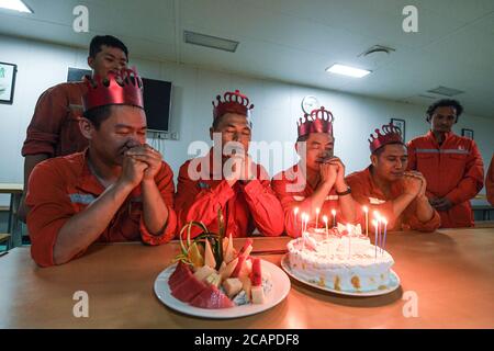 (200808) -- HAIKOU, 8 agosto 2020 (Xinhua) -- i lavoratori fanno auguri durante una festa collettiva di compleanno sulla piattaforma petrolifera offshore Kantan No.3 nelle acque settentrionali del Mar Cinese Meridionale, 22 luglio 2020. Il Kantan No.3 è una piattaforma petrolifera semi-sommergibile sviluppata a livello nazionale dalla Cina nel 1983. I suoi 18 membri del team di trivellazione lavorano 12 ore su 24 senza sosta per rilevare le risorse marine di petrolio e gas, che spesso si trovano in fondali sottomarini da 5,000 a 6,000 metri. La vita sulla piattaforma petrolifera è caratterizzata dalla fatica e dalla noia, poiché il tempo è caldo e non c'è alcun segnale del telefono cellulare. T Foto Stock