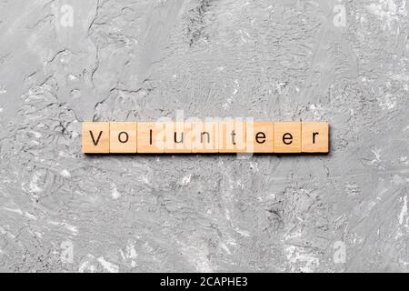 Volunteer parola scritta sul blocco di legno. volontario del testo in tabella, concetto. Foto Stock