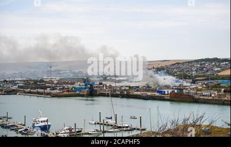 Newhaven UK 8 agosto 2020 - Smoke sorge sopra il porto di Newhaven nel Sussex orientale mentre i vigili del fuoco combattono contro una beffa vicino alla stazione ferroviaria: Credit Simon Dack / Alamy Live News Foto Stock