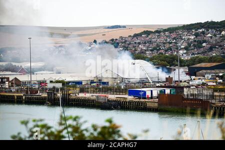 Newhaven UK 8 agosto 2020 - Smoke sorge sopra il porto di Newhaven nel Sussex orientale mentre i vigili del fuoco combattono contro una beffa vicino alla stazione ferroviaria: Credit Simon Dack / Alamy Live News Foto Stock