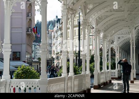 Karlovy Vary Repubblica Ceca ottobre 28 2019. Uomo che guarda in lontananza, scudi con la mano. Vista interna del colonnato del mercato. Foto Stock