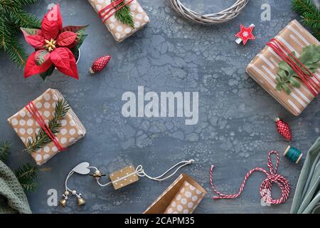 Confezione di regali di Natale, regali, in carta artigianale, carta marrone con puntini astratti e strisce. Sfondo xmas con scatole regalo, rametti d'abete, tessuto Foto Stock