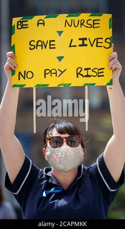 Un lavoratore della NHS si presenta a Millennium Square, Leeds, come parte di una protesta nazionale contro la retribuzione. Foto Stock