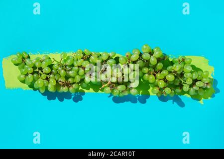Uva verde fresca su sfondo blu con briciolo di vernice Foto Stock