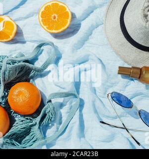 Picnic flatlay di arance in una borsa eco stringa e. cappello su coperta blu Foto Stock