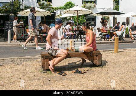 WIMBLEDON LONDRA, REGNO UNITO - 8 AGOSTO 2020. La gente si diverte a bere fuori del pub Crooked Billet in un pomeriggio caldo e umido su Wimbledon Common dopo la giornata più calda registrata in 17 anni a piedi come il tempo caldo e le alte temperature sono previste per durare in tutta l'Inghilterra meridionale fino alla settimana prossima. Credit: amer Ghazzal/Alamy Live News Foto Stock