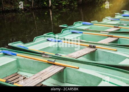 Vecchie barche verdi vuote con remi di legno sulla chioseup del lago. Imbarcazioni da diporto. Foto Stock