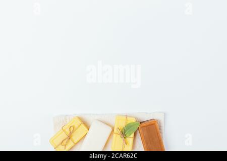 Saponi organici fatti a mano su tavolo bianco con spazio libero, vista dall'alto. Foto Stock