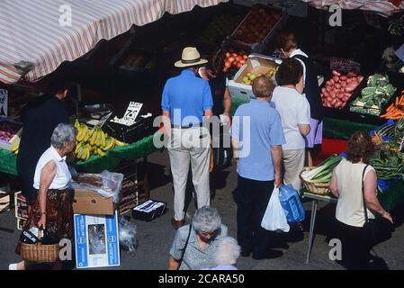 I clienti si accodano in una bancarella di frutta e verdura. Mercato di Horncastle, Lincolnshire, Inghilterra, Regno Unito Foto Stock