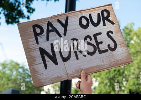 I lavoratori del NHS (National Health Service) marciano in protesta dal St. Thomas' Hospital a Downing Street, Londra, per chiedere un aumento salariale al governo. Foto Stock