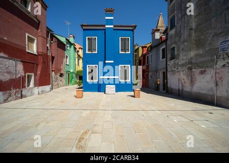 Isola di Burano, Laguna Veneziana, Venezia, Italia, una piccola casa di colore blu su una piazza campo nel centro della città Foto Stock