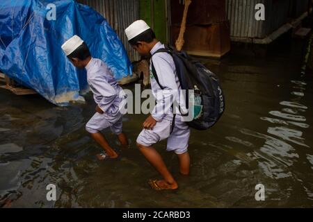 Dhaka, Dhaka, Bangladesh. 8 agosto 2020. Due ragazzi sono stati visti muoversi attraverso una strada allagata a Barda Ruppanj, mentre l'acqua del fiume Balu sale. 08 agosto 2020. Dhaka, Bangladesh. Credit: Nayem Shaan/ZUMA Wire/Alamy Live News Foto Stock