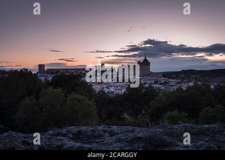 Paesaggio urbano del villaggio di Uclés con il monastero e il castello in cima alla collina al tramonto, Cuenca, Castilla la Mancha, Spagna Foto Stock