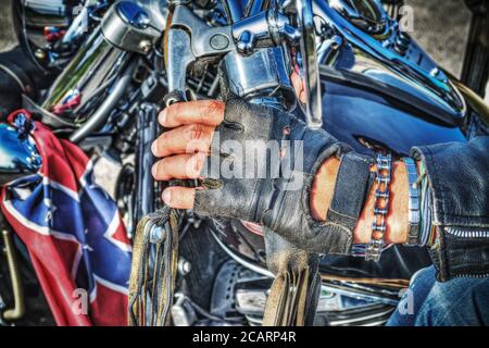 primo piano di una mano biker con un guanto sul manubrio Foto Stock