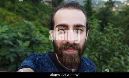 Uomo hipster con fare videochiamate con la fotocamera in mani Primo piano POV Foto Stock