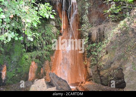 Acqua dalla Fuente Agria de Prtugos, a Granada, Spagna. Formare un piccolo ruscello che passa attraverso Alpujarra. Foto Stock