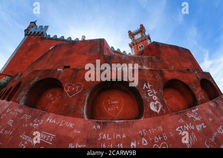 Sintra, Portogallo - 4 febbraio 2019: Nomi, parole e messaggi d'amore scritti e incisi sulla parete rossa del Palazzo pena, colorato castello di Sint Foto Stock