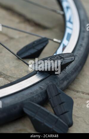 Le pastiglie dei blocchi dei freni pericolosamente usurate danno luogo a metallo su metallo attrito con il cerchione usurato sul profilo del controbattitore e inferiore buche meccanicamente resistenti Foto Stock