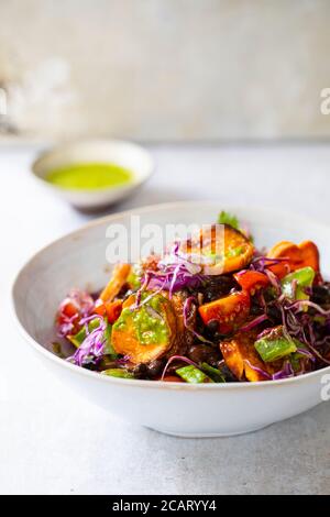 Ciotola vegana con fagioli neri, patate dolci arrosto, cavolo rosso e avocado Foto Stock